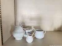 Four creamers grouped on shelf