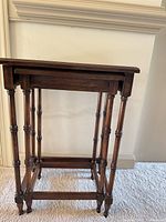 Side view of both nested tables showing turned legs and wood finish