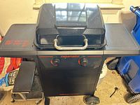 Full view of closed black Megamaster grill with side shelves