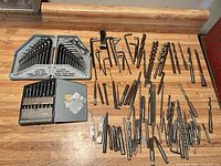 Overview of all drill bits, hex key sets and other metal bits on workbench