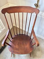 Front angled view showing seat, spindle back, arms and stained finish