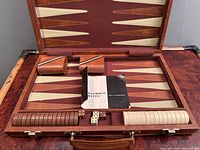 open backgammon case showing board, checkers, dice, cups and booklet