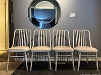 Front view of four white bentwood chairs in a row