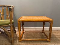 Perspective of entire bamboo rattan side table next to chair