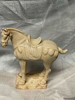 full left-front view of glazed ceramic horse on base