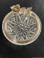 Top view showing cut glass starburst pattern and silverplated floral rim