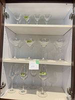 Cabinet view showing three shelves of matching clear stemware