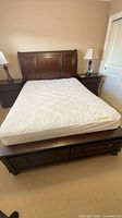 Full view of assembled queen sleigh bed frame, mattress shown but not included