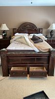 Full view of bed with drawers open showing stained interiors
