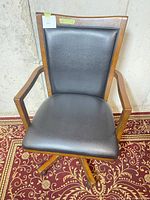 Full front view of chair showing wood frame, upholstery and base