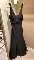 Front view of full-length black dress on hanger