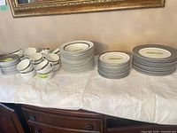 Stacked cups, saucers, bowls, lunch and dinner plates on table
