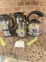Group shot showing kettle, two French presses and frothing pitcher on countertop