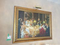 Full view of framed replica painting on wall with picture light