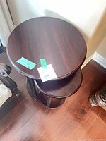 Two stacked round wooden tables showing size and finish