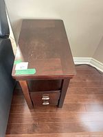 Side angle of table beside sofa highlighting drawers and wood finish