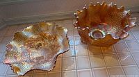 Both marigold carnival glass bowls side by side