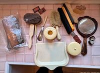 Entire vanity set items laid out including brushes, mirror, shoehorns, crumb tray, containers, razor blade boxes