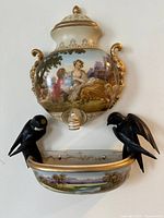 Full view of assembled porcelain wall fountain with lid, reservoir, spigot, basin, bird figures