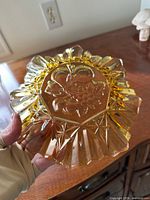 Bottom view of amber ruffled bowl showing intaglio fruit design