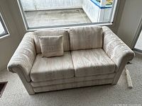 loveseat front view showing upholstery, pillow, arm style