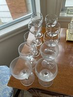 Nine frosted stemmed wine glasses on table