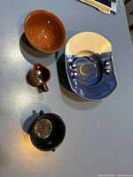 Group shot of all four items: ikebana bowl, Gibson's creamer, Gibson's bowl, metal cauldron