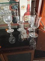 Four straight-sided goblets displayed on cabinet surface