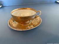 Japanese Satsuma teacup on matching saucer showing exterior gilt design