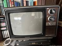 Front view of Electrohome TV atop Toshiba and Samsung VCRs, showing wood-grain panel and tuning knobs