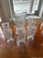 Front view of pitcher and six tumblers displaying pattern and footing