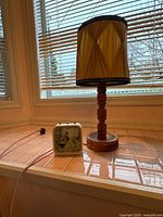 Lamp and clock together on tiled sill