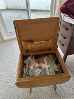 Stool open showing storage compartment filled with sewing supplies