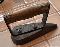 Cast iron sad iron showing full shape, handle, finger guard