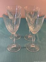 Four crystal wine glasses standing upright on surface