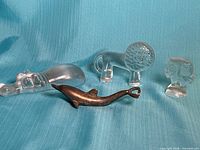 Group shot of three glass animal figurines and metal dolphin bottle opener