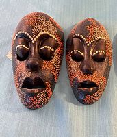 Front view of both Indonesian masks on blue cloth