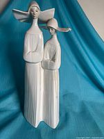 Front view of Lladro white porcelain figurine showing two nuns in habits