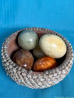 Bowl filled with five stone eggs