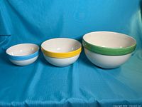 All three nested ceramic bowls displaying size difference and coloured rims
