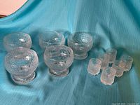 Group shot of five dessert cups and six liqueur glasses on fabric backdrop