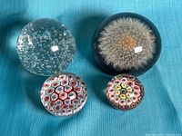 Group shot of four paperweights on blue fabric