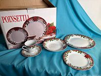 Box and sample place setting showing dinner plate, salad plate, bowl, cup and saucer