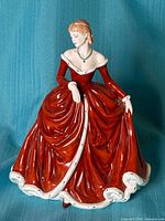 Front view of Royal Doulton figurine showing red gown and necklace
