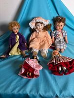 Group shot of all five dolls on blue cloth