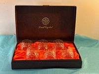 Closed Webb black presentation case showing logo and satin interior with six glasses