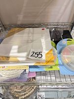 Stack of wrapped canvases with round paint palette and other accessories visible