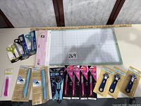 Overview of entire lot showing mats, scissors, rotary cutters, X-ACTO knives, Cricut tools