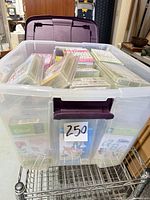 Plastic storage bin filled with sealed Cricut cartridges