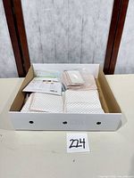 Tray holding fabric stacks, pouch of pens and packaging